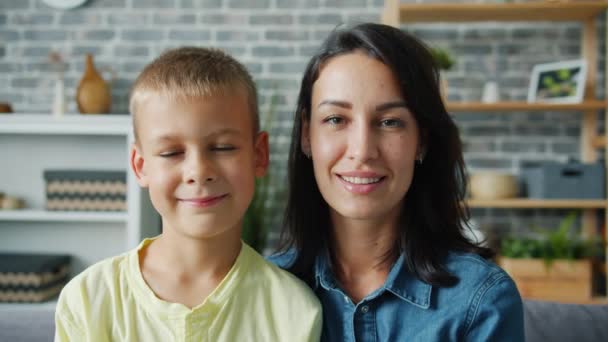 Медленно движущийся портрет матери и маленького мальчика в квартире, улыбающихся вместе — стоковое видео