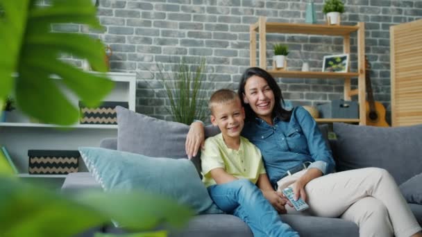 Žena a chlapec sledování zábavné show na TV smějící se trávení volného času doma — Stock video