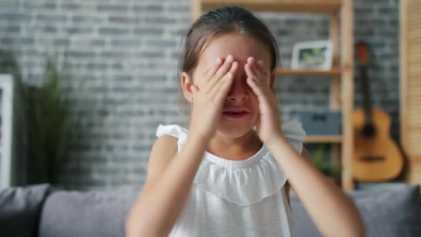 Portret van een schattig klein meisje dat verstoppertje speelt ogen verbergt met lachende handen — Stockvideo