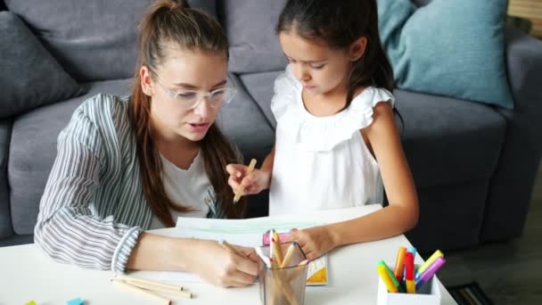 Família feliz filha e mãe desenho quadro à mesa no apartamento — Vídeo de Stock