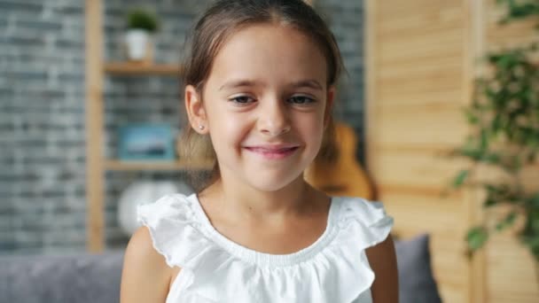 Πορτρέτο του όμορφου γλυκό κοριτσάκι χαμογελώντας στην κάμερα στο σπίτι και μόνο — Αρχείο Βίντεο