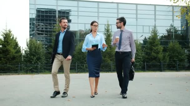 Grupo de jóvenes empresarios caminando juntos al aire libre conversando — Vídeos de Stock