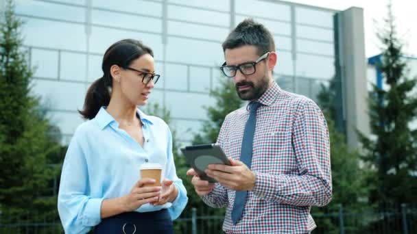 Happy people business partners talking laughing outdoors using tablet computer — 图库视频影像