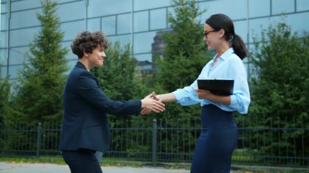 Socias de negocios que se reúnen al aire libre estrechándose las manos intercambiando saludos — Vídeos de Stock