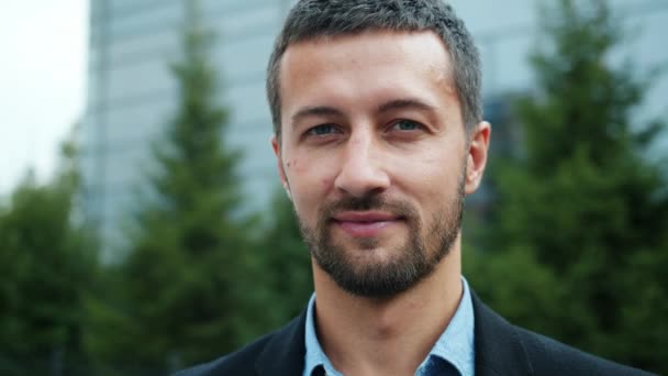 Close-up slow motion portrait of smiling male entrepreneur outdoors in city street — Stock Video