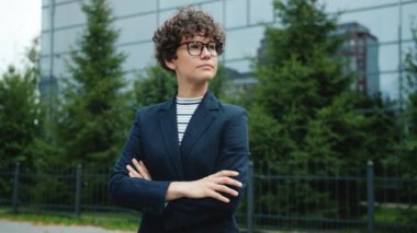 Gözlüklü ve takım elbiseli kadın iş adamının portresi dışarıda kameraya yansıyor.