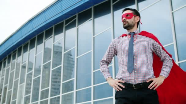 Portrét ambiciózního muže s červenou maskou superhrdiny a pláštěm stojící venku — Stock video