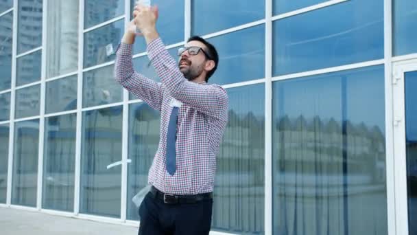 Rijke man gooien geld buiten dansen plezier vieren zakelijk succes — Stockvideo