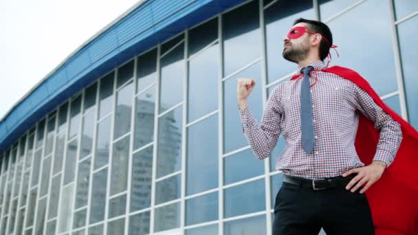 Retrato de un hombre divertido haciendo gestos de superhéroes y luego corriendo a los grandes negocios — Vídeos de Stock