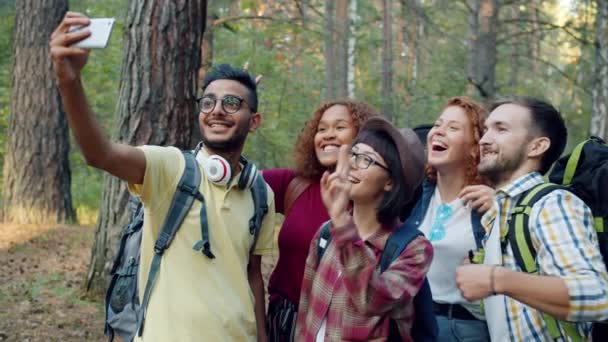 Groupe d'amis touristes prenant selfie en forêt à l'aide de la caméra smartphone posant — Video