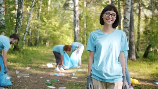 Jovem mulher moderna eco-ativista se voltando para a câmera na floresta sorrindo fora — Vídeo de Stock