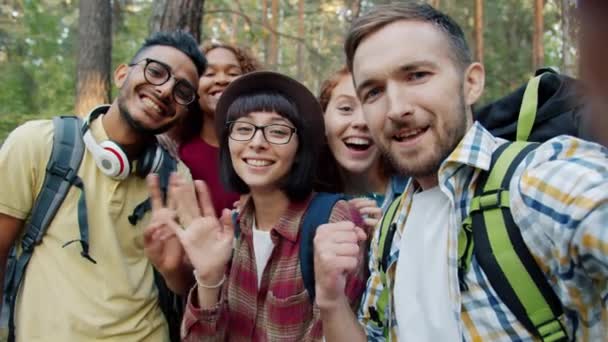 Point de vue portrait de jeunes gens joyeux en selfie voyageant dans la forêt — Video