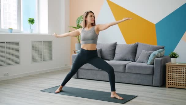 Schattige jonge dame doet sport thuis oefenen op yoga mat gericht op activiteit — Stockvideo