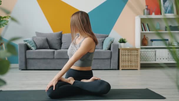 Hermosa mujer haciendo yoga relajante en loto asana con las manos en gesto namaste — Vídeo de stock