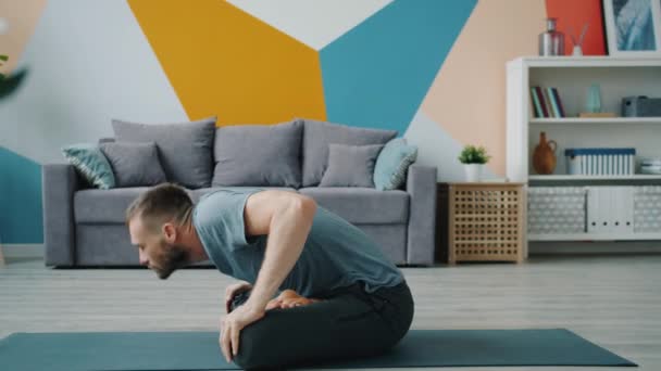 집에서 건강 한 척추를 위한 운동을 하는 멋진 스포츠맨의 측면 뷰 — 비디오