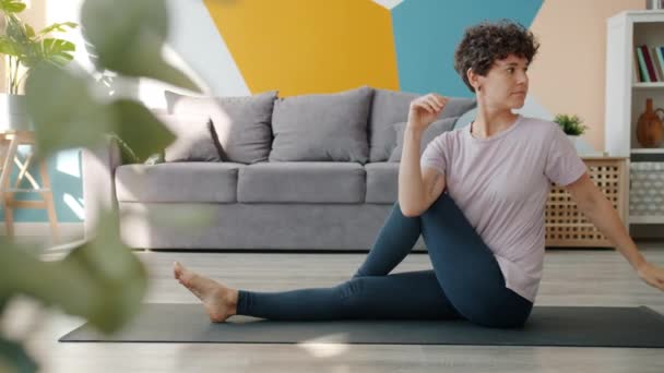 Belle dame faisant de l'exercice à la maison faisant du yoga étirant le corps en prenant soin de la santé — Video