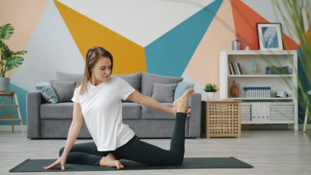 Niedliche blonde Stretching Beine Yoga zu Hause auf Matte Pflege für die Gesundheit des Körpers — Stockvideo