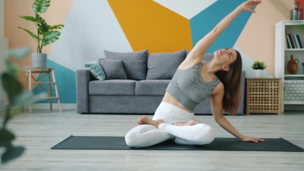 Yoga-Studentin macht Übungen und entspannt sich dann in Lotus-Pose mit den Händen im Mudra — Stockvideo