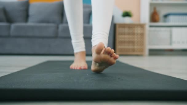 Låg skott slow motion av en kvinna som rullar ut yogamatta träna i planka position — Stockvideo