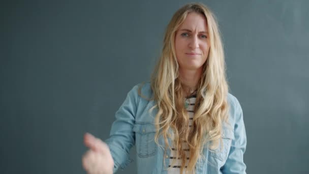 Porträtt av besviken flicka visar tummen-down hand gest ser olycklig — Stockvideo