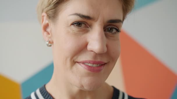 Facial portrait of beautiful adult woman with short blond hair smiling at camera — 비디오