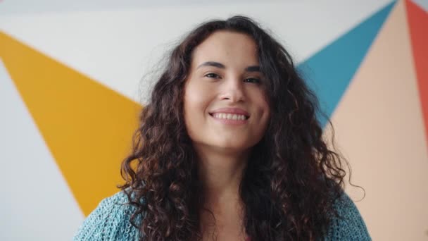 Porträt einer fröhlichen Studentin mit gemischter Rasse, die drinnen lächelt und sich glücklich fühlt — Stockvideo