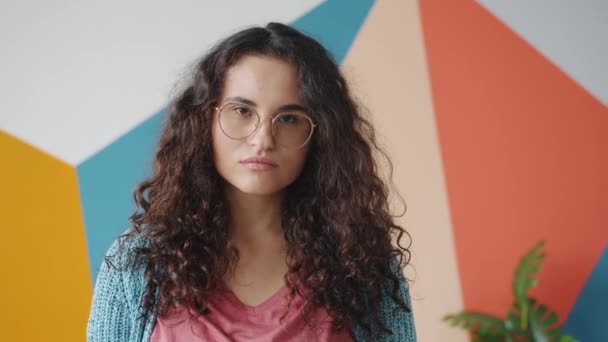 Portré, ha komoly és szomorú lány néz kamera színes háttér beltéri — Stock videók