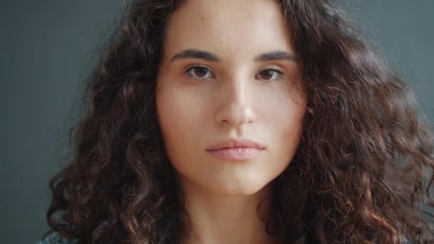 Retrato de impresionante chica asiática seria luego sonriendo sobre fondo gris oscuro — Vídeos de Stock