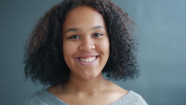 Portret radosnego afro-amerykańskiego ucznia uśmiechającego się na czarnym tle, szczęśliwego — Wideo stockowe