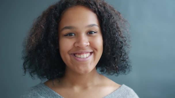 Portrait of joyful Afro-American student smiling on black background feeling happy — Stock Video