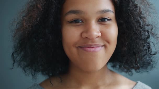 Kameraya bakıp gülümseyen çekici Afro-Amerikalı kadının yakın plan portresi. — Stok video
