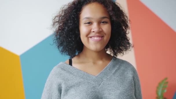 Retrato de la alegre dama afroamericana saludando con la mano en el interior sonriendo saludo — Vídeo de stock