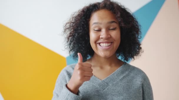 Atractiva mujer afroamericana mostrando un gesto de pulgar hacia arriba con sonrisa alegre — Vídeo de stock