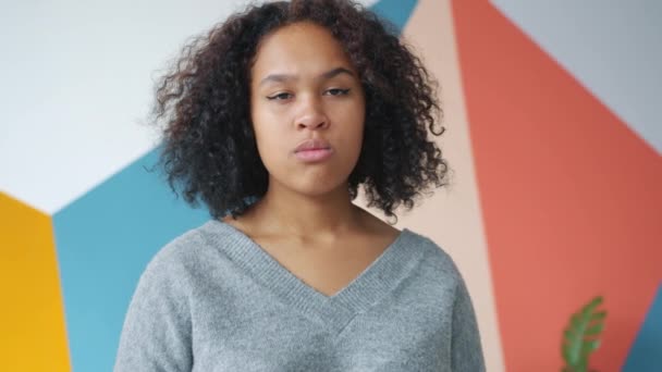 Movimento lento de calma, mas furiosa menina afro-americana olhando para a câmera com raiva — Vídeo de Stock