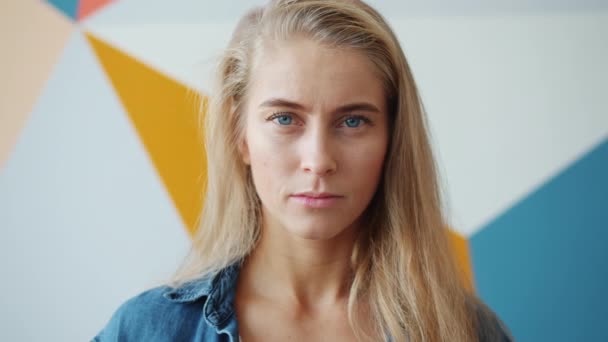 Close-up portrait of adorable young woman serious then laughing looking at camera — Stock Video