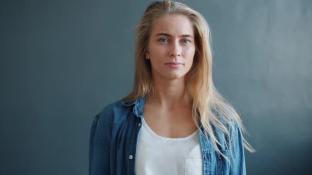 Retrato de alegre amigável jovem senhora acenando a mão e sorrindo no fundo escuro — Vídeo de Stock