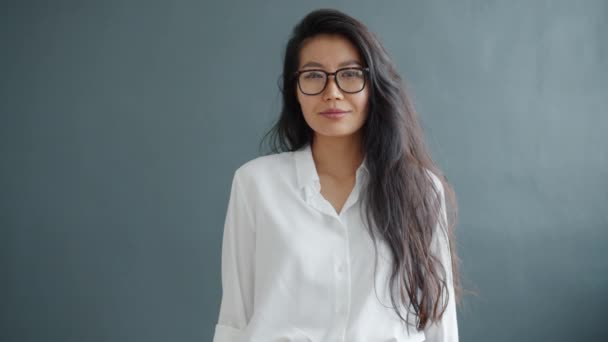 Retrato de la señora asiática alegre mostrando gesto de la mano ok sobre fondo gris sonriendo — Vídeos de Stock