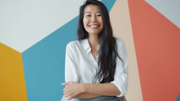 Zpomalený pohyb šťastný asijský student smích s úsměvem na barevném pozadí — Stock video