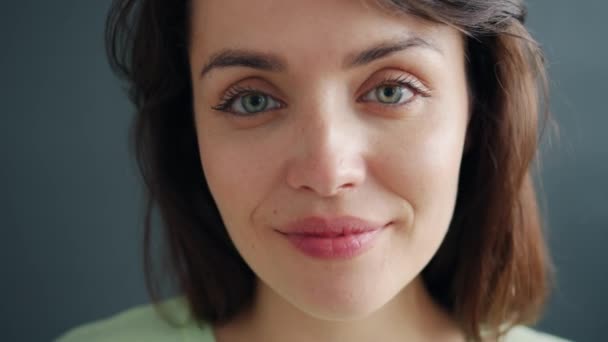 Close-up portret przystojny młody brunetka patrząc na kamery w studio — Wideo stockowe