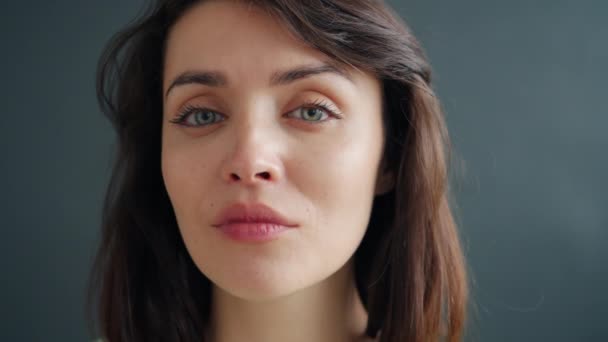 Gezichtsportret van goed uitziende jonge vrouw met donker haar ernstig dan glimlachen — Stockvideo