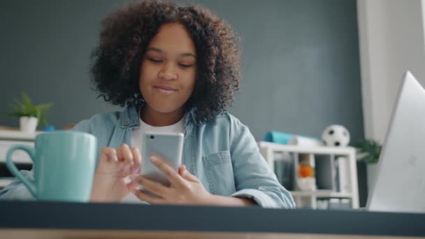 Жінка-офіс працівник, використовуючи смс-повідомлення смартфона, що працює в офісі сам — стокове відео