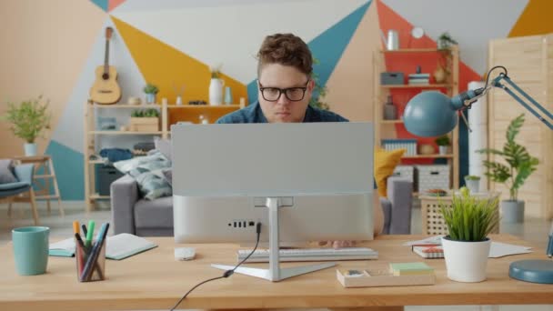 Exitoso freelancer trabajando en casa usando laptop sentado en el escritorio en el estudio escribiendo — Vídeos de Stock