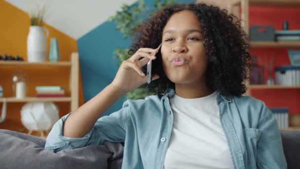 Movimento lento da jovem afro-americana falando no celular em casa — Vídeo de Stock