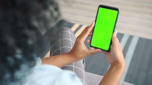 Visão traseira da morena segurando chroma chave verde tela smartphone assistir conteúdo — Vídeo de Stock