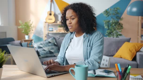 興奮したアフリカ系アメリカ人ビジネス女性が自宅でフリーランスの仕事で成功を収めています — ストック動画