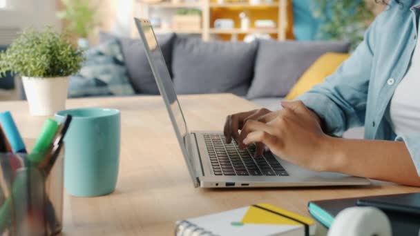 Close-up de mãos femininas digitando no laptop na mesa em casa fazendo trabalho freelance — Vídeo de Stock