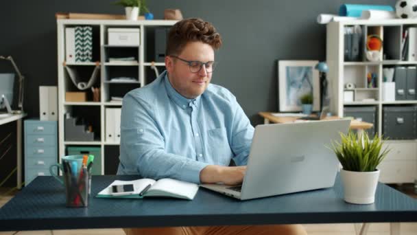Allvarlig affärsman stilig kille skriva med bärbar dator inomhus på kontoret — Stockvideo