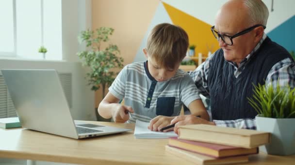 Öreg és gyerek laptoppal csinálják a házi feladatot, aztán pacsiznak.