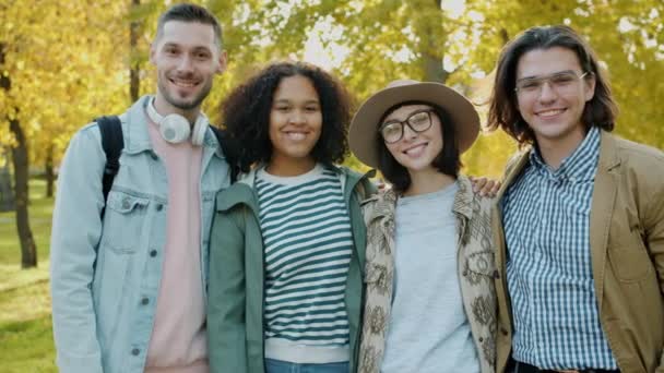 Portrait of attractive girls and guys smiling standing in urban park in autumn — Stock Video