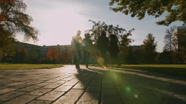 Visão traseira de amigos felizes andando ao ar livre na cidade fazendo high-five rindo — Vídeo de Stock